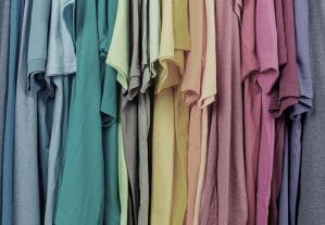 a rainbow collection of hanging t-shirts