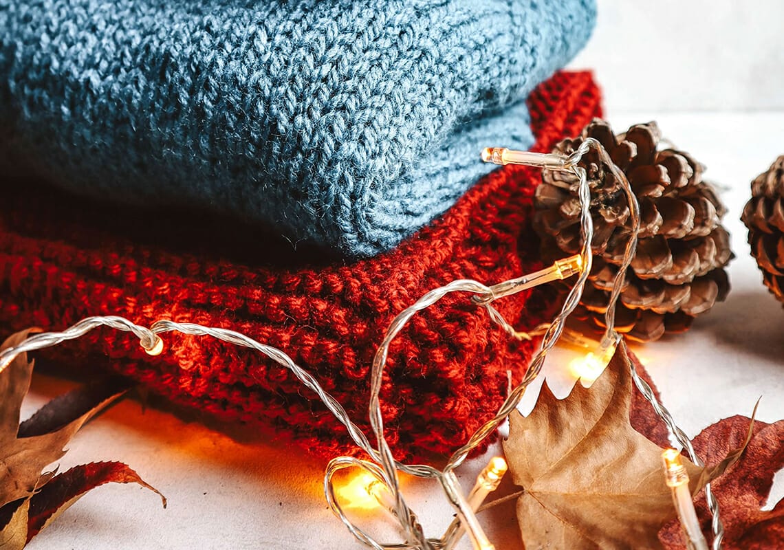 folded sweaters and fall leaves