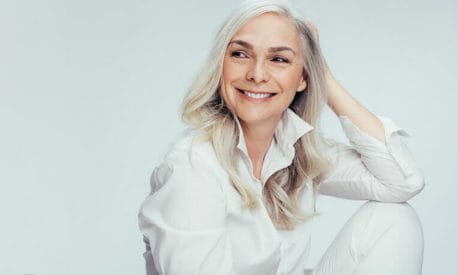 A stylish women with grey hair in a white shirt