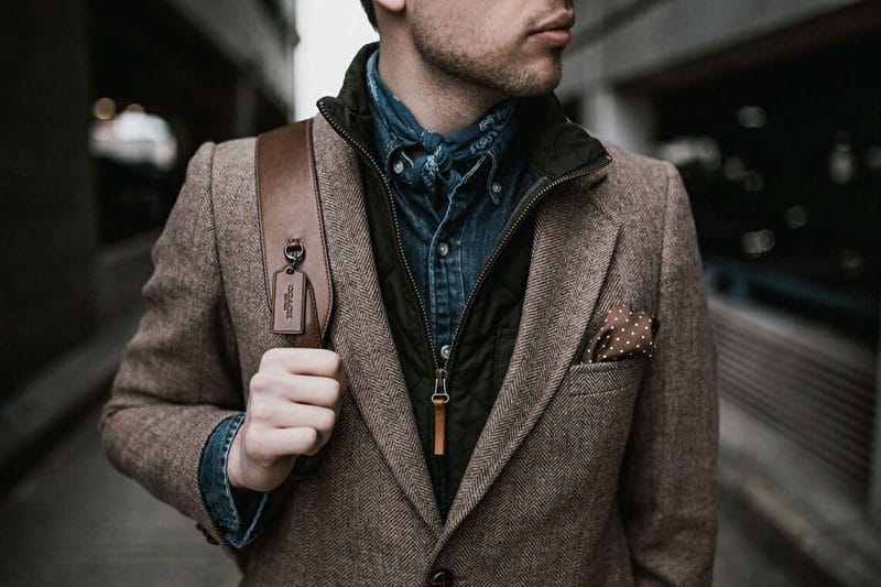 a close up of a man in a smart jacket and denim shirt